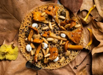 Plato de setas sobre tortilla y hojas con aspecto otoñal.