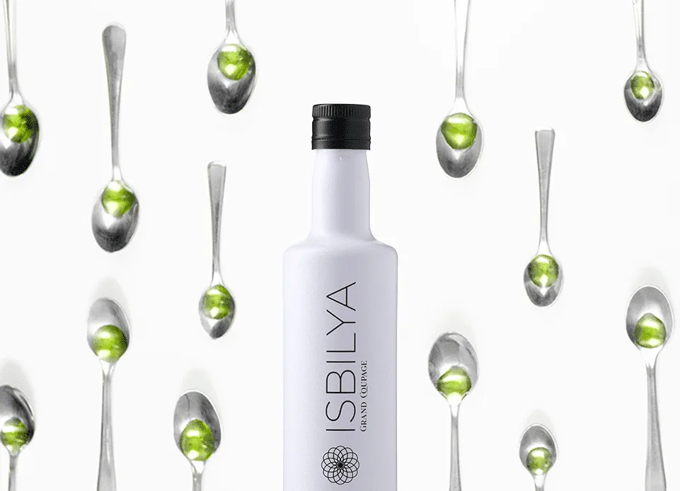 Botella Isbilya grand coupage rodeada de cucharillas con AOVE premium.