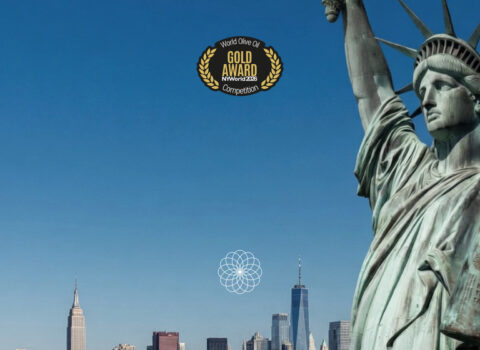 Estatua de la libertad levantando botella de Isbilya Sikitita celebrando la medalla de oro en Nueva York Olive oil Competition