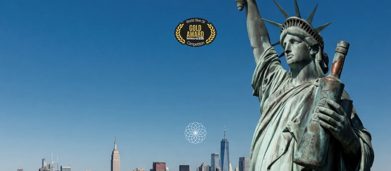 Estatua de la libertad levantando botella de Isbilya Sikitita celebrando la medalla de oro en Nueva York Olive oil Competition