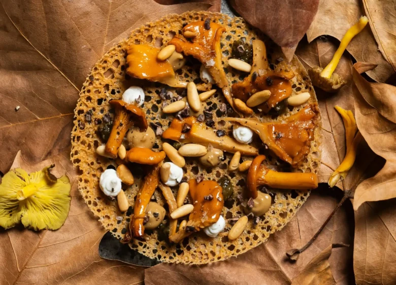 Plato de setas sobre tortilla y hojas con aspecto otoñal.